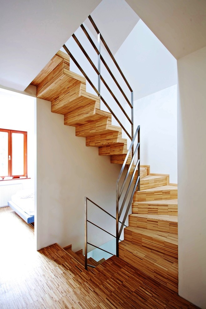 Inspiration for a mid-sized contemporary wooden curved staircase remodel in Other with wooden risers