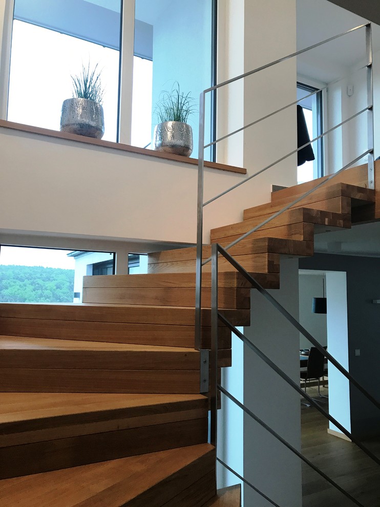 Gewendelte, Große Moderne Holztreppe mit Holz-Setzstufen und Stahlgeländer in Sonstige