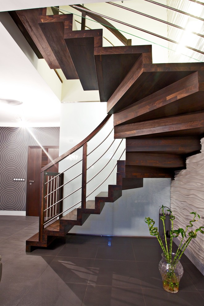 Foto de escalera curva actual grande con escalones de madera y contrahuellas de madera
