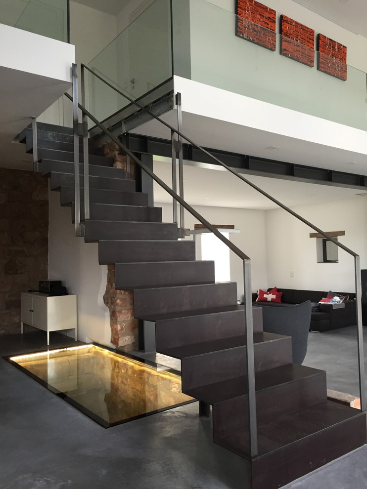 Cette photo montre un grand escalier droit tendance avec des marches en métal, des contremarches en métal et éclairage.