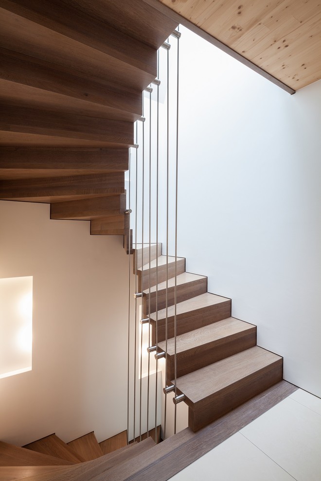 Источник вдохновения для домашнего уюта: изогнутая деревянная лестница среднего размера в современном стиле с металлическими перилами и деревянными ступенями