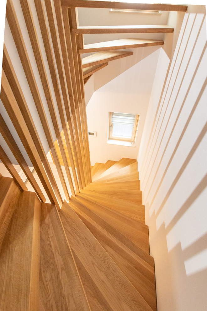 Modelo de escalera curva moderna con escalones de madera, contrahuellas de madera y barandilla de madera