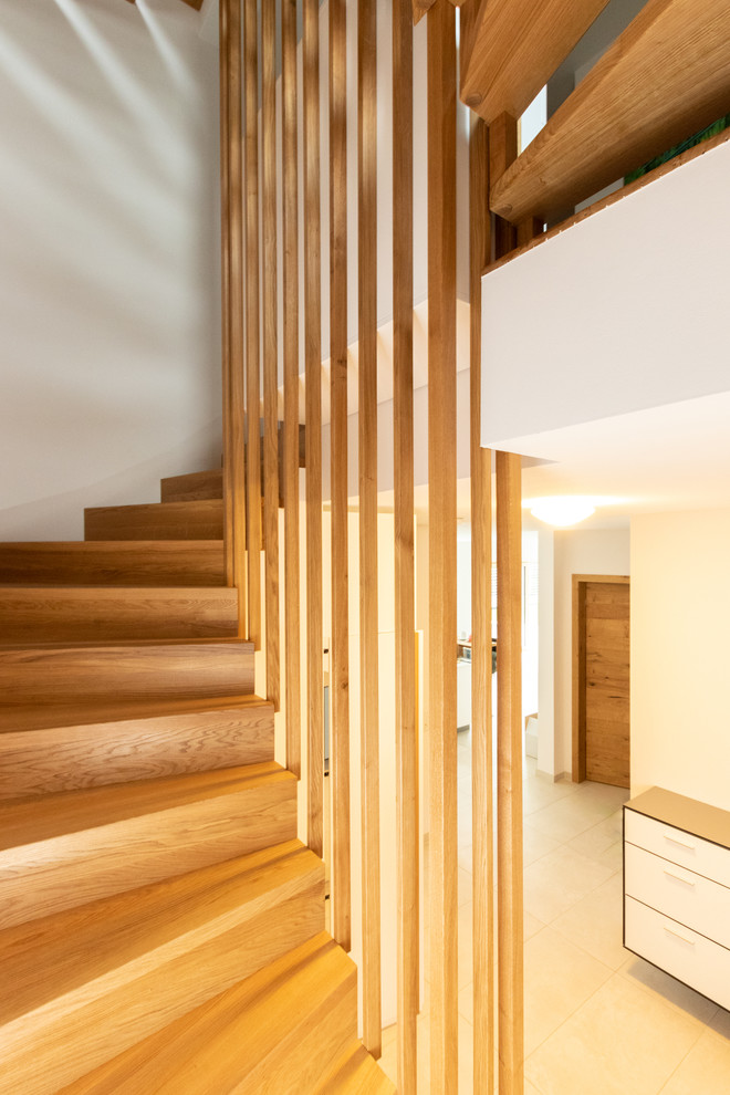 Diseño de escalera curva moderna con escalones de madera, contrahuellas de madera y barandilla de madera
