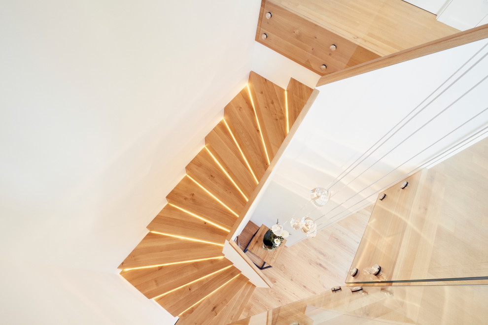 Стильный дизайн: маленькая изогнутая деревянная лестница в современном стиле с деревянными ступенями и деревянными перилами для на участке и в саду - последний тренд
