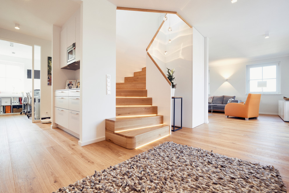 Diseño de escalera curva actual pequeña con escalones de madera, contrahuellas de madera y barandilla de madera
