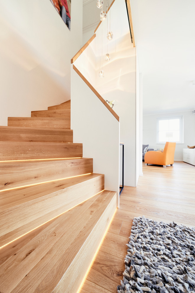 Стильный дизайн: маленькая изогнутая деревянная лестница в современном стиле с деревянными ступенями и деревянными перилами для на участке и в саду - последний тренд