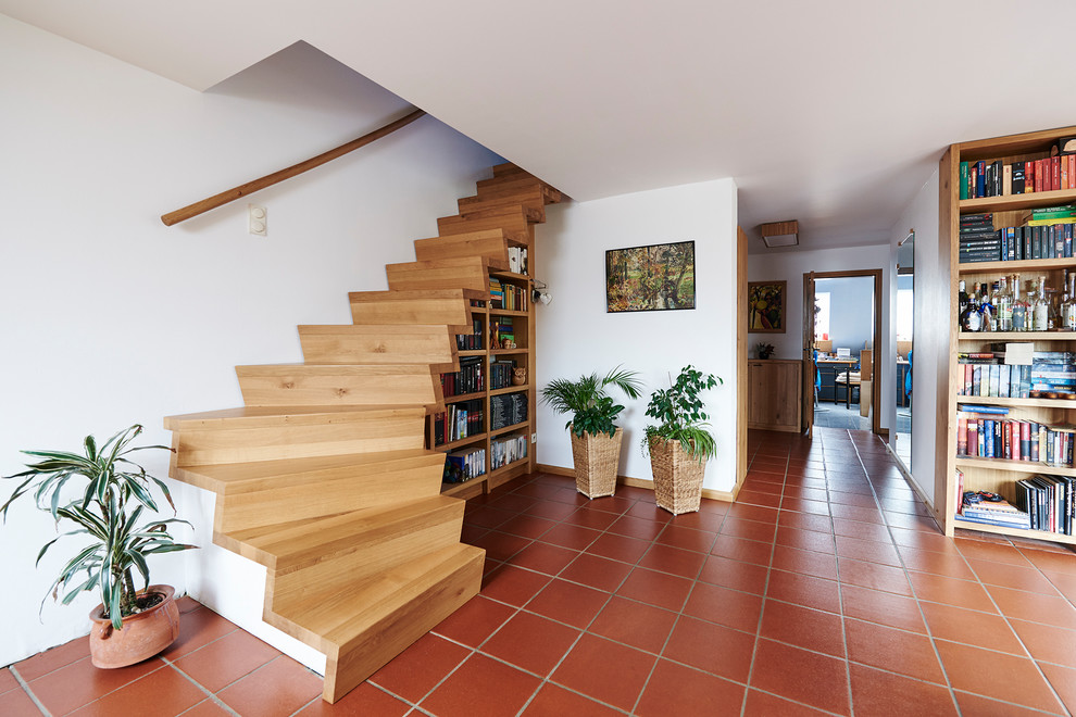 Idée de décoration pour un escalier méditerranéen en L de taille moyenne avec des marches en bois, des contremarches en bois et un garde-corps en bois.