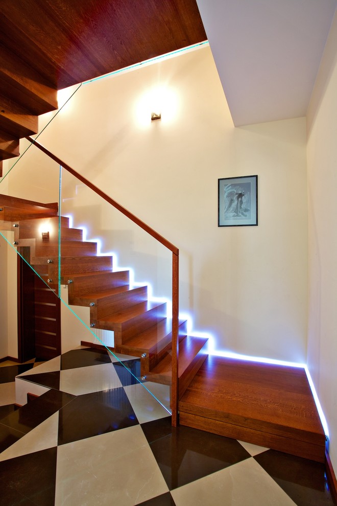 Aménagement d'un grand escalier droit contemporain avec des marches en bois et des contremarches en bois.