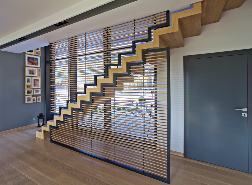 Photo of a large retro wood straight staircase in Other with wood risers.