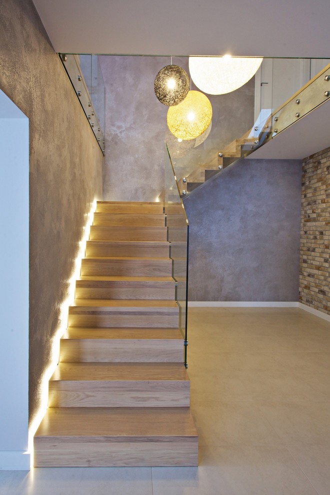 This is an example of an expansive contemporary wood l-shaped staircase in Other with wood risers.