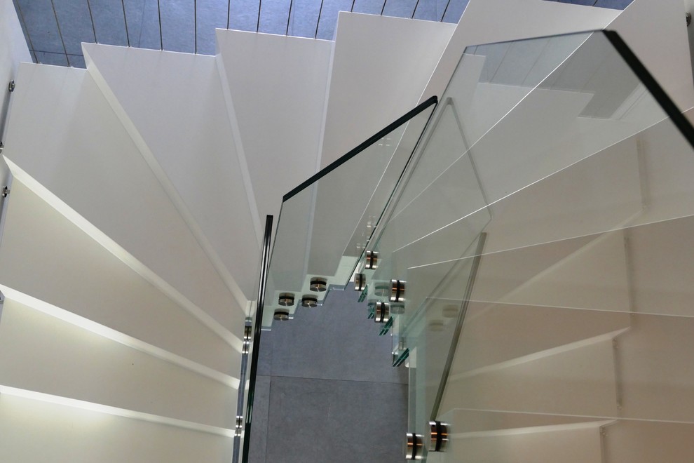 Ejemplo de escalera curva contemporánea grande con escalones de madera y contrahuellas de madera