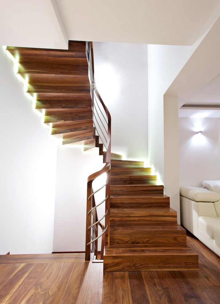 Modelo de escalera curva actual grande con escalones de madera y contrahuellas de madera