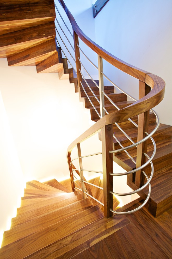 Diseño de escalera curva actual grande con escalones de madera y contrahuellas de madera