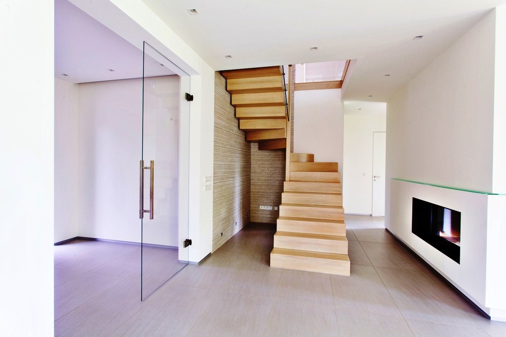 This is an example of a large contemporary wood curved staircase in Other with wood risers.