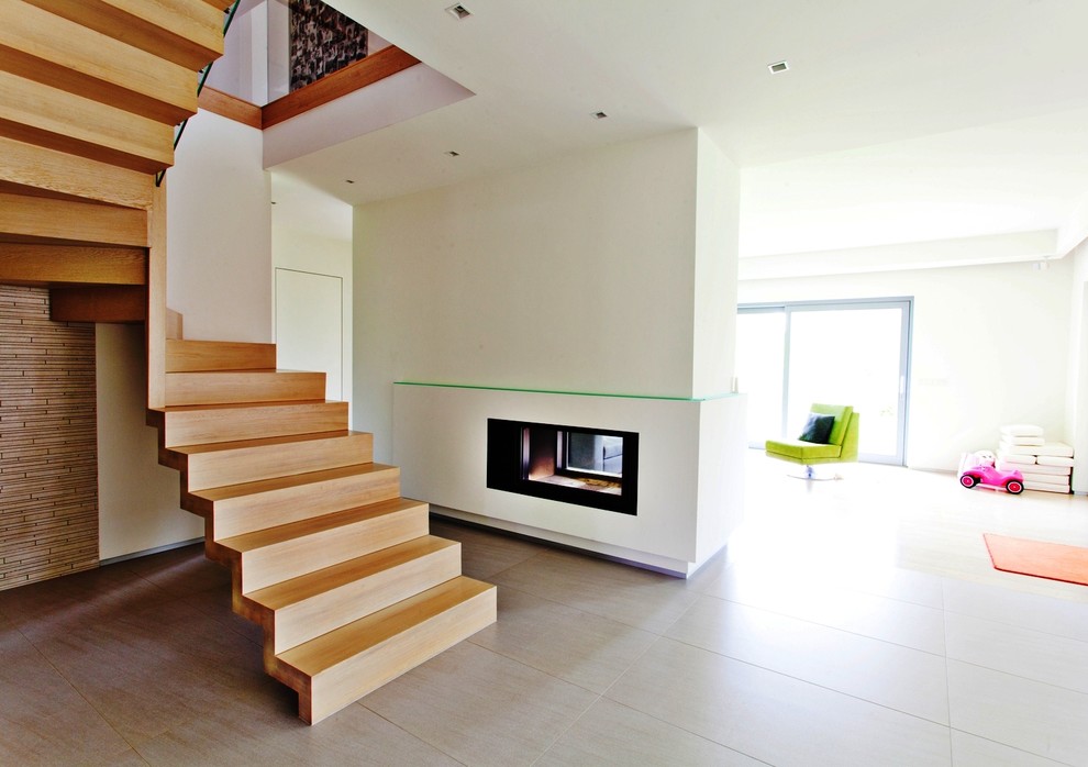 Пример оригинального дизайна: большая изогнутая деревянная лестница в современном стиле с деревянными ступенями
