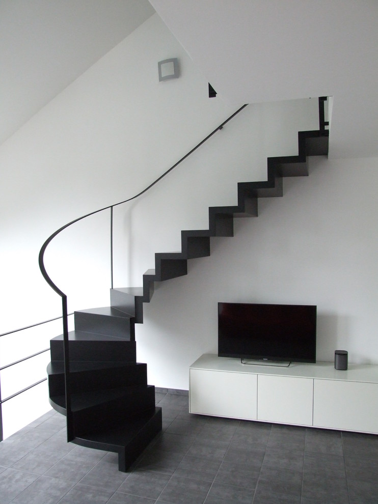Foto de escalera curva minimalista pequeña con barandilla de metal, escalones de madera y contrahuellas de madera