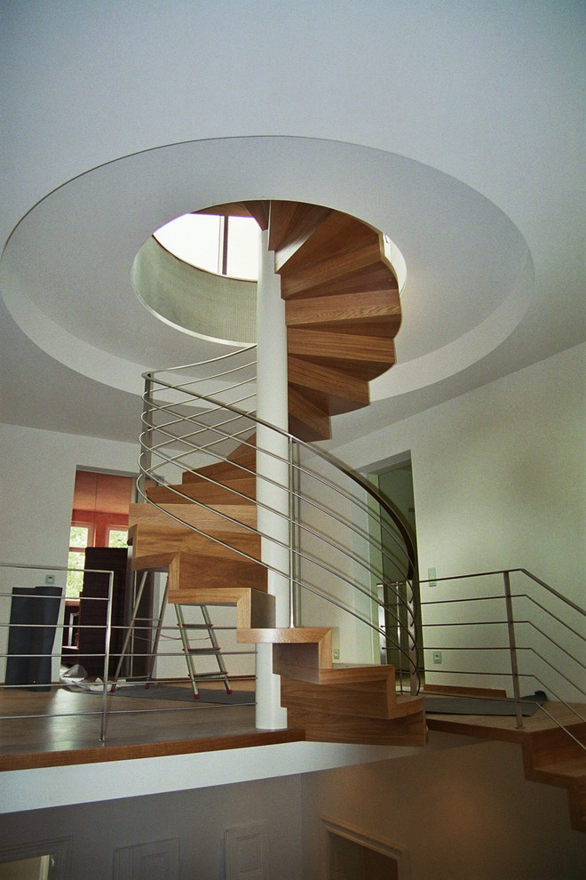 Idee per un'ampia scala contemporanea con pedata in legno, alzata in legno e parapetto in metallo