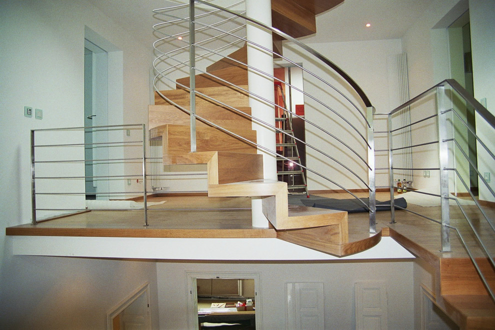 На фото: огромная деревянная лестница в современном стиле с деревянными ступенями и металлическими перилами с