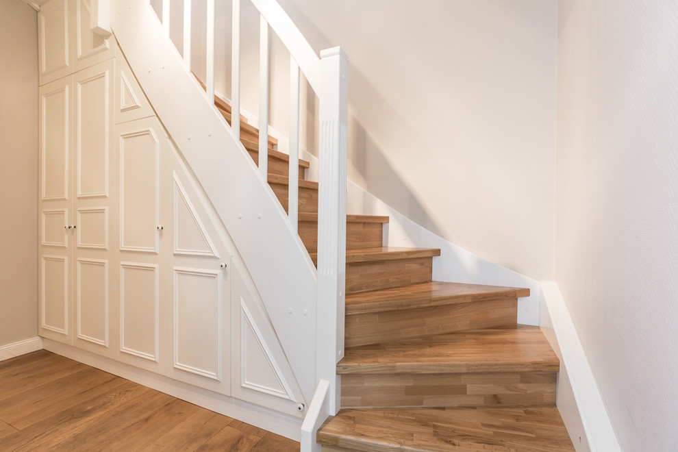 Cette image montre un escalier courbe nordique de taille moyenne avec des marches en bois, des contremarches en bois et rangements.