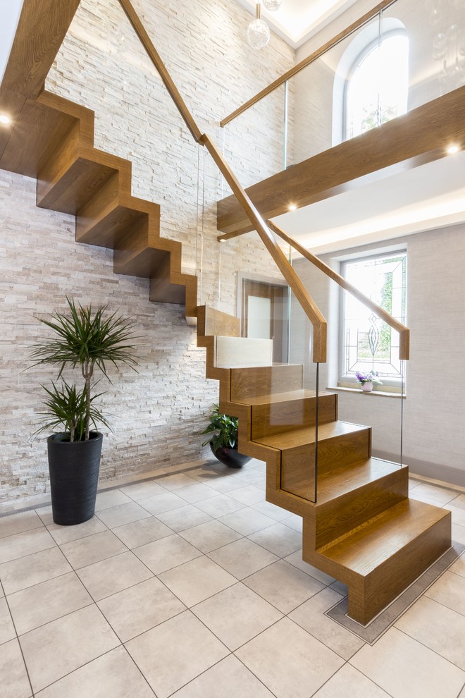 Idées déco pour un escalier contemporain en L de taille moyenne avec un garde-corps en verre, des marches en bois et des contremarches en bois.