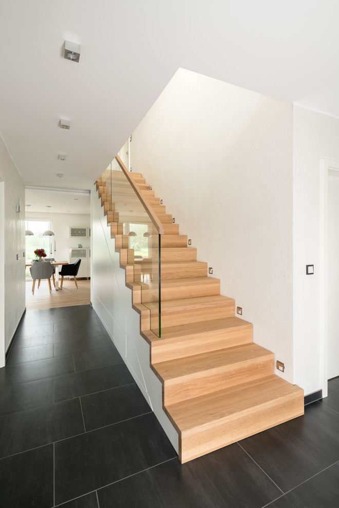Inspiration for a medium sized contemporary painted wood straight glass railing staircase in Nuremberg with painted wood risers.