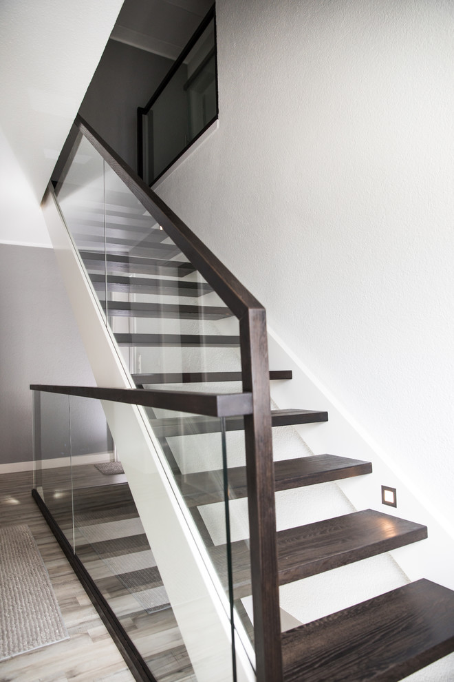 Imagen de escalera recta contemporánea con escalones de madera y barandilla de vidrio