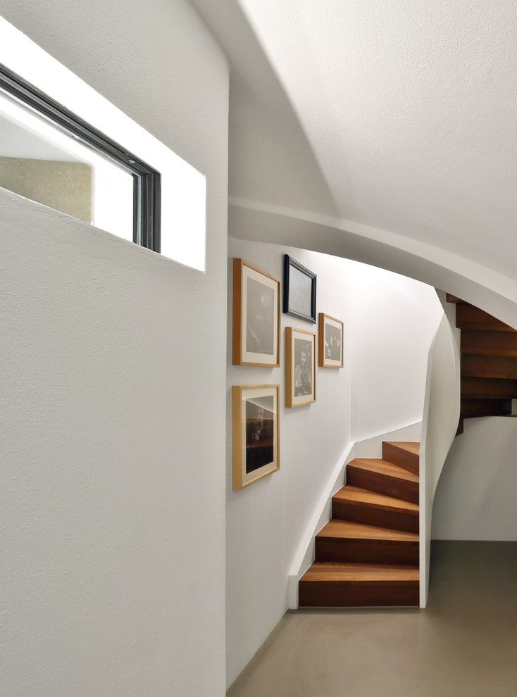 Inspiration pour un petit escalier courbe minimaliste avec des contremarches en bois, un garde-corps en bois et des marches en bois.