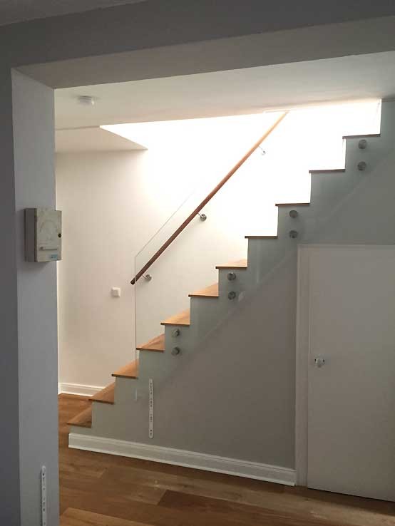 Пример оригинального дизайна: большая прямая бетонная лестница в современном стиле с деревянными ступенями и стеклянными перилами