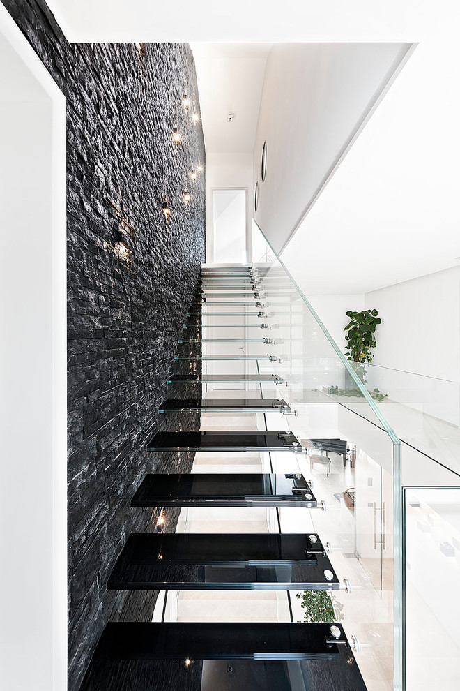 Photo of a medium sized contemporary glass straight glass railing staircase in Munich with open risers.