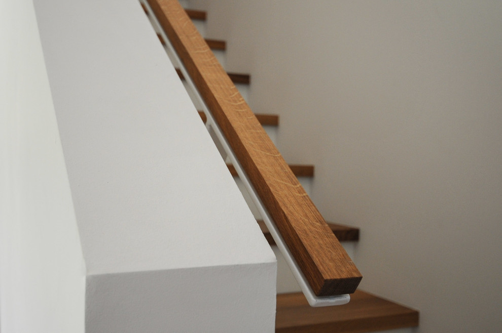 Exempel på en mellanstor skandinavisk rak trappa i trä, med räcke i flera material