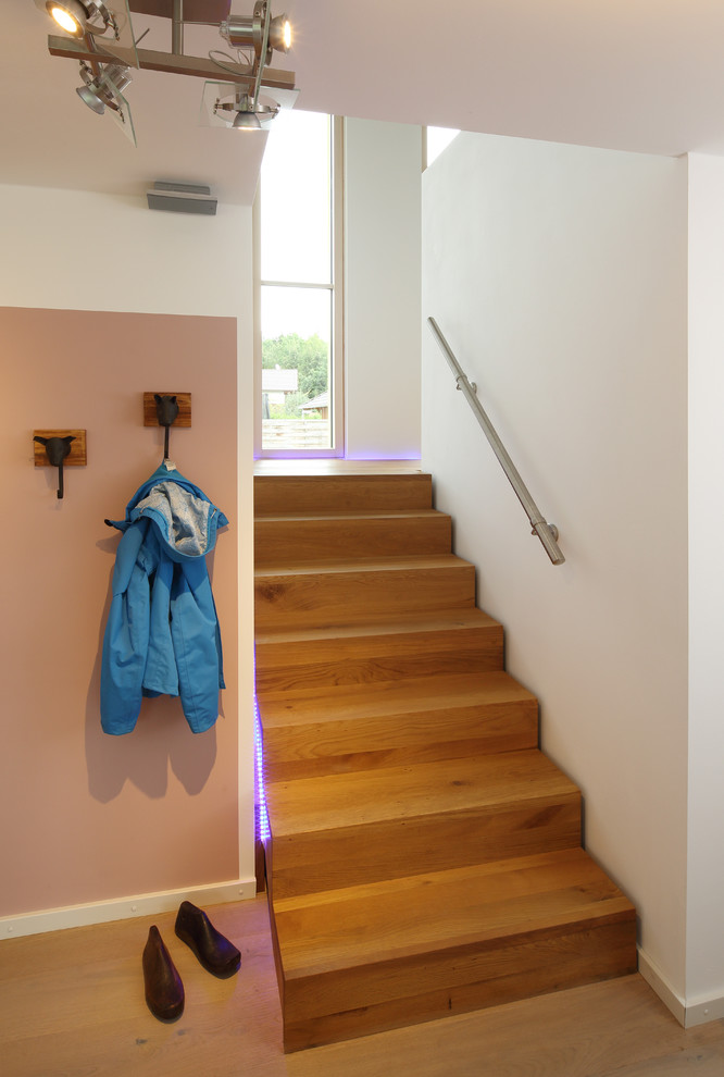 Réalisation d'un escalier design en U de taille moyenne avec des marches en bois peint, des contremarches en bois et un garde-corps en métal.
