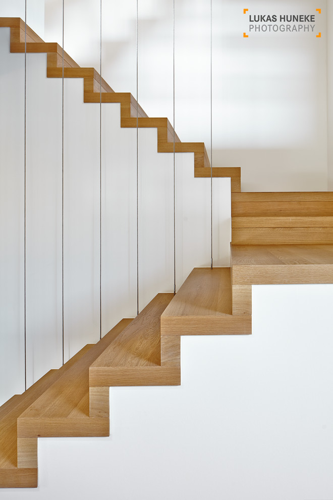 Foto de escalera suspendida contemporánea extra grande con escalones de madera y contrahuellas con baldosas y/o azulejos