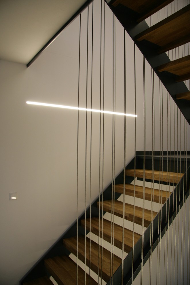 Foto de escalera en U contemporánea pequeña sin contrahuella con escalones de madera