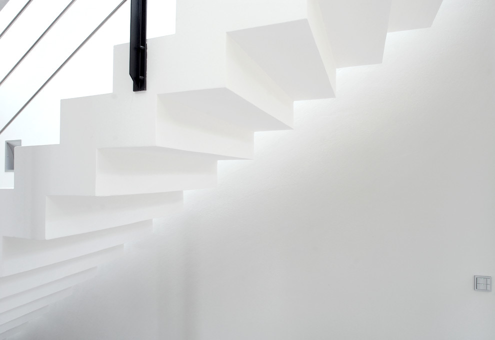Diseño de escalera suspendida minimalista de tamaño medio con escalones con baldosas, contrahuellas con baldosas y/o azulejos y barandilla de metal
