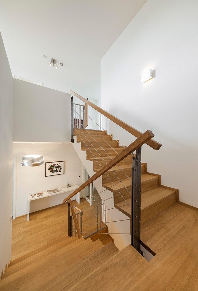 Design ideas for a medium sized contemporary wood u-shaped wood railing staircase in Cologne with wood risers.