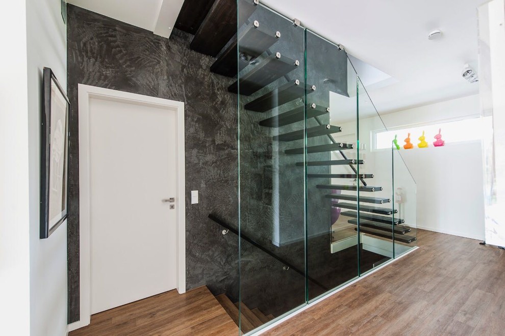 Idée de décoration pour un escalier sans contremarche droit design de taille moyenne avec des marches en bois peint et un garde-corps en verre.