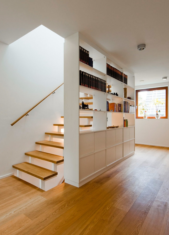 Ejemplo de escalera recta actual de tamaño medio sin contrahuella con escalones de madera y barandilla de madera
