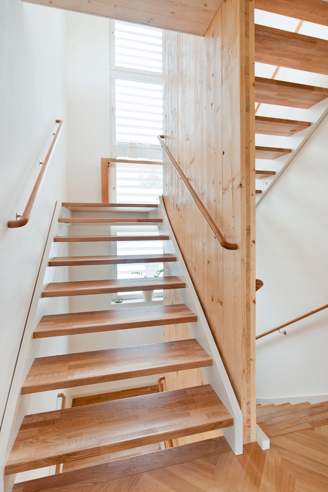 Imagen de escalera en U con escalones de madera y barandilla de madera