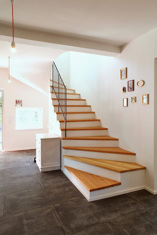 Idée de décoration pour un grand escalier courbe tradition avec des marches en bois.