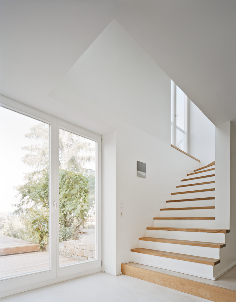 Стильный дизайн: большая п-образная лестница в современном стиле с деревянными ступенями - последний тренд