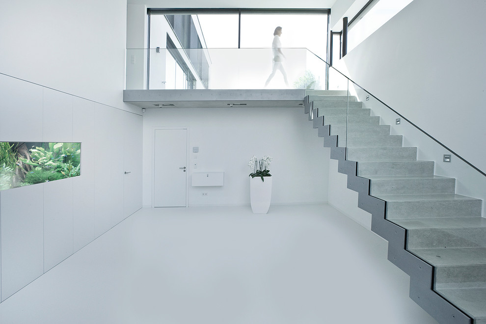 Aménagement d'un escalier droit contemporain en béton avec des contremarches en béton.