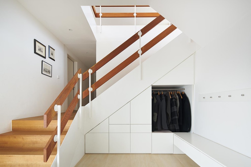 Idée de décoration pour un escalier design en U de taille moyenne avec des marches en bois, des contremarches en bois et rangements.