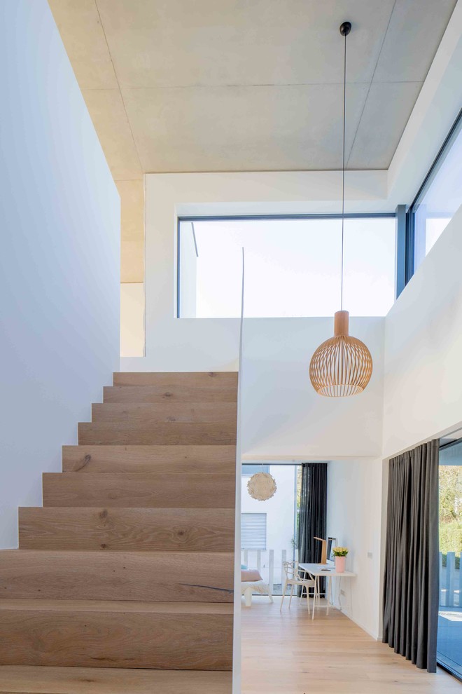 Diseño de escalera recta minimalista de tamaño medio con escalones de madera, contrahuellas de madera y barandilla de metal
