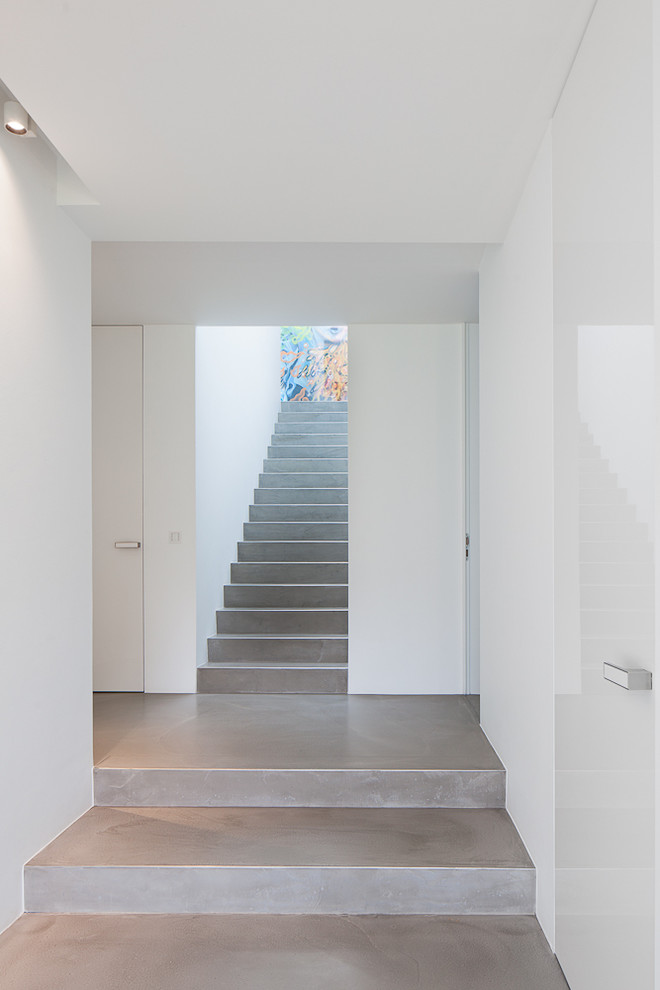 Réalisation d'un grand escalier droit design en béton avec des contremarches en béton.