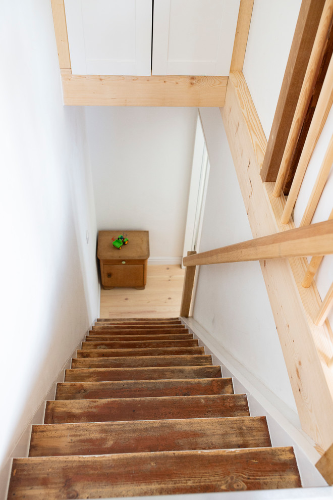 Ejemplo de escalera escandinava pequeña con escalones de madera, contrahuellas de madera y barandilla de madera