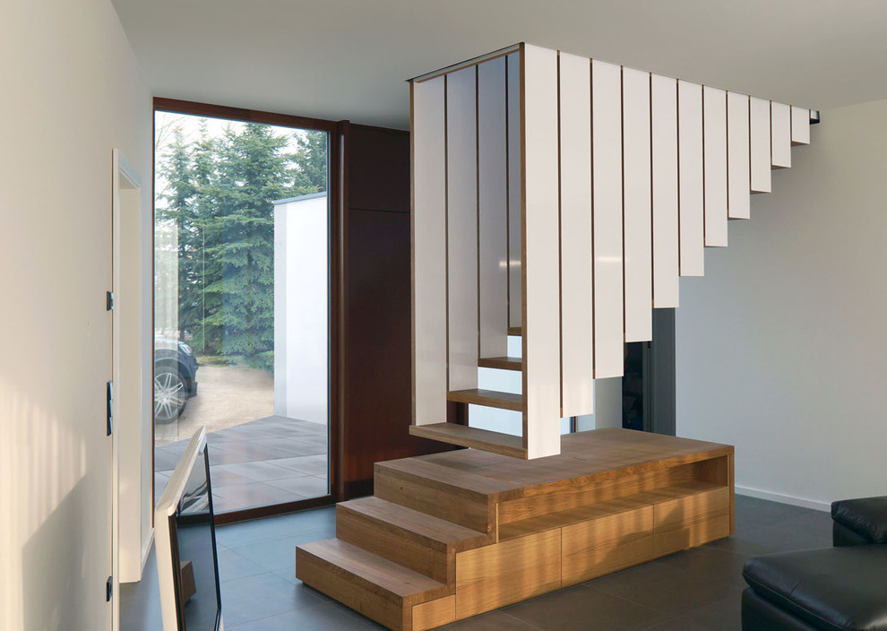 На фото: лестница на больцах, среднего размера в современном стиле с деревянными ступенями без подступенок с