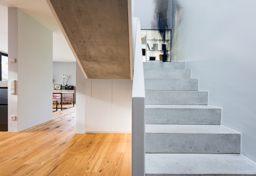 Mittelgroße Moderne Treppe in U-Form mit Beton-Setzstufen in Leipzig