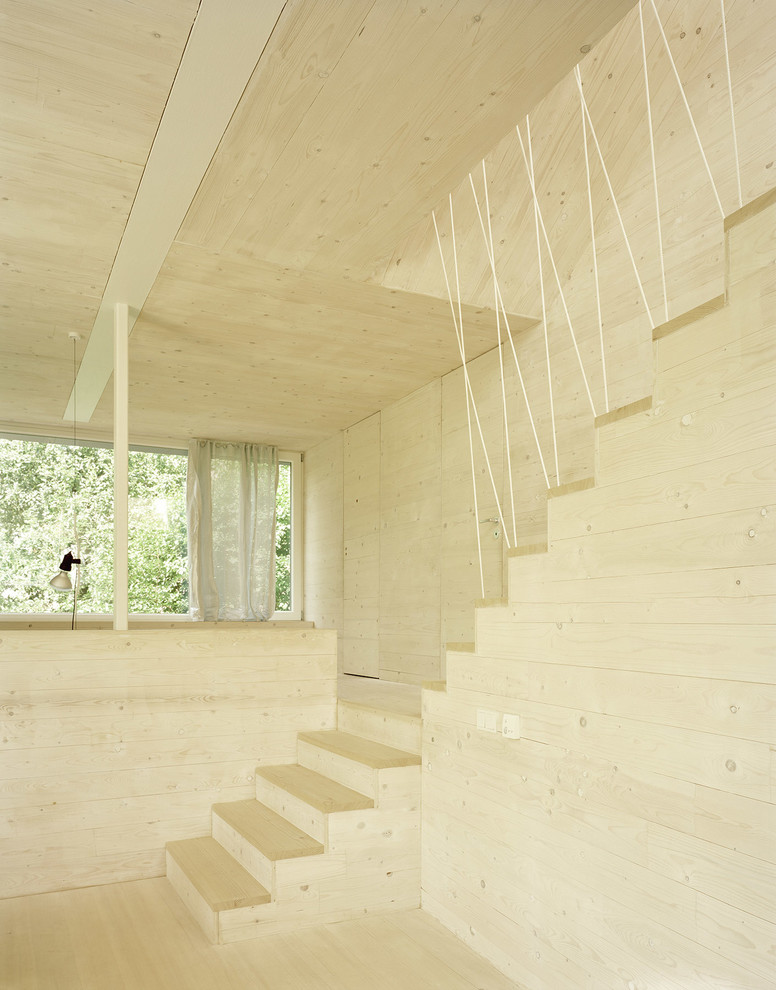 На фото: деревянная лестница в стиле модернизм с деревянными ступенями