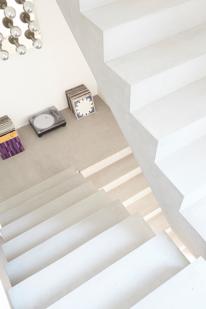 Стильный дизайн: бетонная лестница на больцах, среднего размера в стиле модернизм с бетонными ступенями и стеклянными перилами - последний тренд