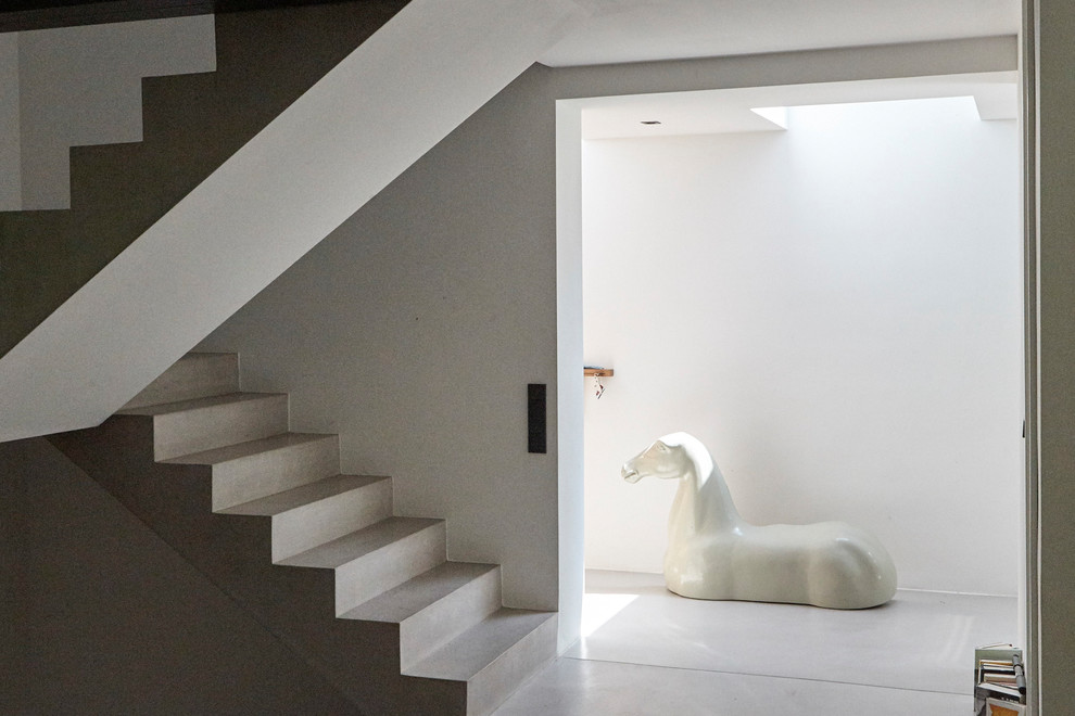 Источник вдохновения для домашнего уюта: большая бетонная лестница на больцах в стиле модернизм с бетонными ступенями и стеклянными перилами